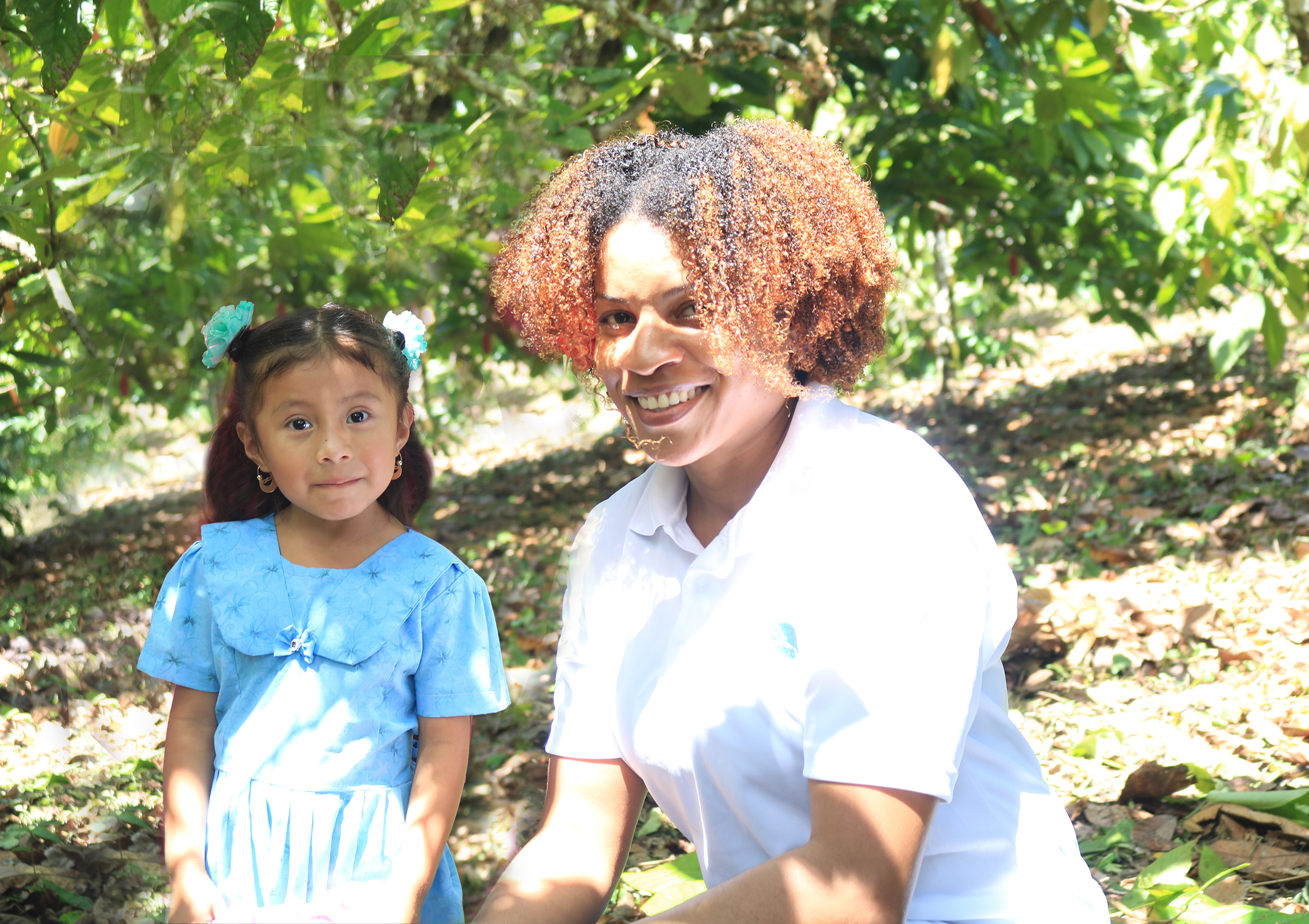 female CDB staff member smiling posing next to a small child