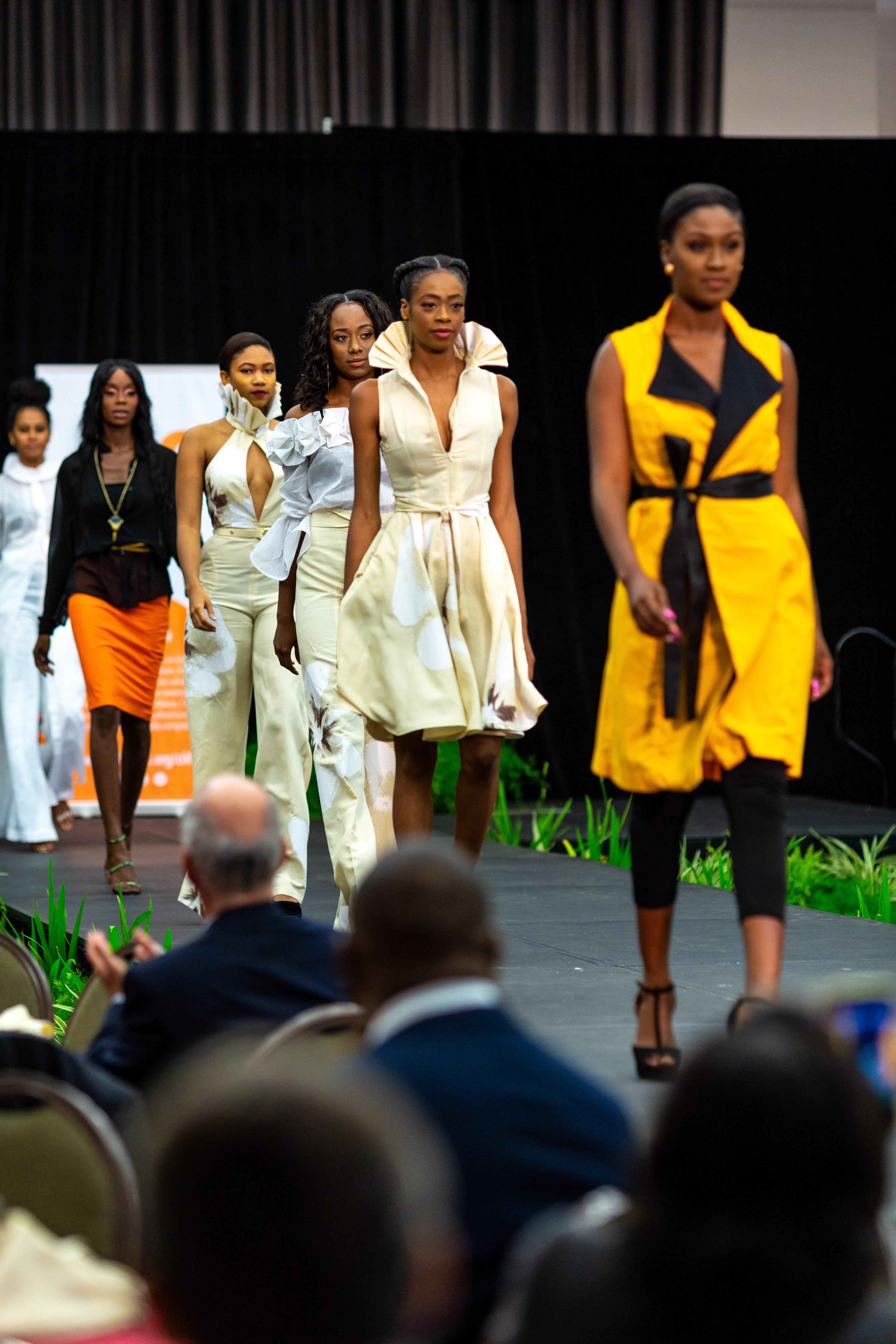 Line of models in colourful outfits on catwalk