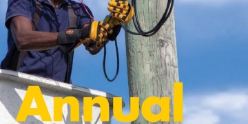 Worker in Antigua installing LED streetlight.