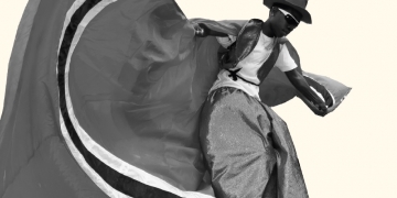 Beige cover with black and white photo of stilt walker