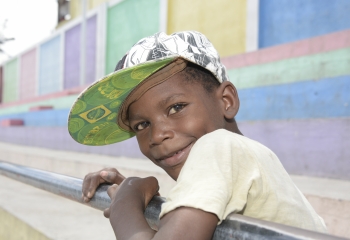 young boy with cap on looking into the camera