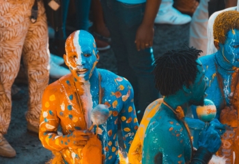 Haitian Carnival revellers in blue and orange paint