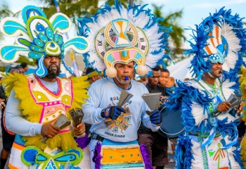 Three men in Bahamas Junkanoo costumes playing music