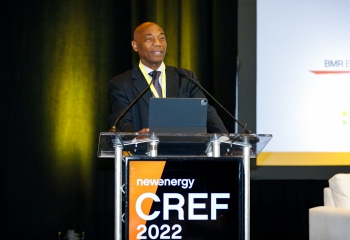 Dr. Leon wearing a dark suit standing lectern with CREF branding