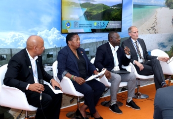 Four panelists seated on stage in front of audience