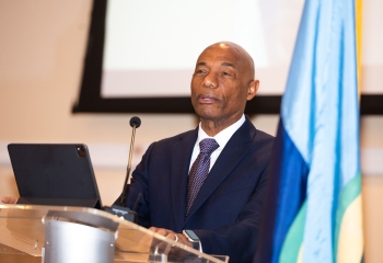 gentleman in dark suit delivering lecture at lectern