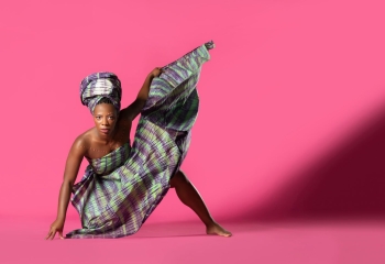 dancer posing against pink background