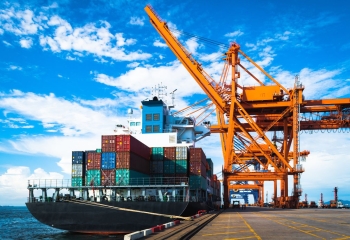 cargo ship being offloaded at a port