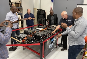 British Columbia Institute of Technology's Electric Vehicle (EV) instructors showing EV Study Tour participants an EV battery in the EV teaching lab in Vancouver.