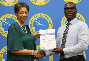 smiling female accepting certification for completion of a course