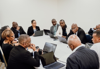 A group of individuals sitting around a table in discussion. 