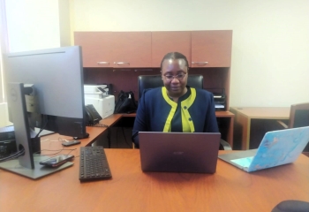 Amoi Romeo seated at her desk 