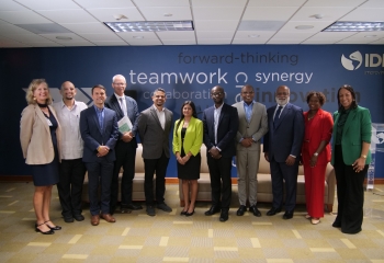 Group of Caribbean persons standing in business attire in an office space