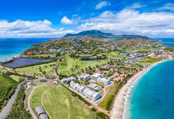 Aerial view of Saint Kitts and Nevis showing blue seas and skies white sands greenery and rooftops at daytime 