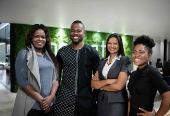 Portrait of a diverse group of smiling young black businesspeople standing together in the lobby of a modern office