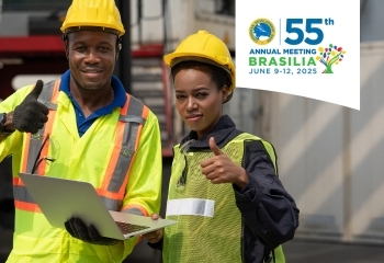 The image of two construction workers in safety gear give thumbs-up gestures, symbolizing teamwork and development.  The logo for the 55th Annual Meeting of the Caribbean Development Bank (CDB), scheduled for June 9-12, 2025, in Brasília, Brazil, is prominently displayed in the top right corner.
