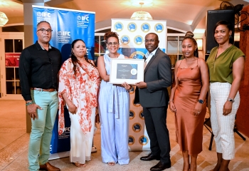 Group of business persons standing with two persons holding a certificate 
