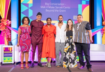 group of three women and three men dressed in colourful attire standing together on stage 