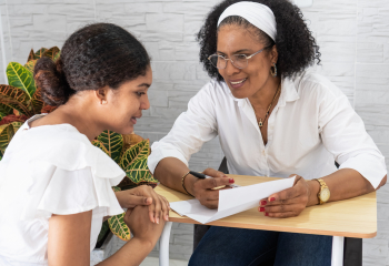 Older woman speaking to a younger woman about a document