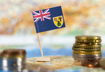 Turks and Caicos flag on a map with coins