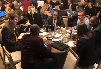 A group of professionals sitting at a roundtable having a discussion.