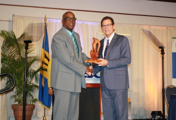 CDB president Dr Warren Smith accepting a token of appreciation from Barbados Small Business Association president Wayne Willock
