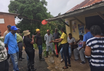 group of male and female farmers stand outside a rural shop talking