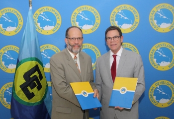 CARICOM SEcretary General Irwin LaRocque and CDB President Dr Warren Smith shaking hands.