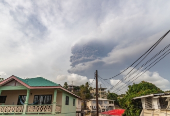 clouds of ash rise above homes in St. Vincent after volcano eruption