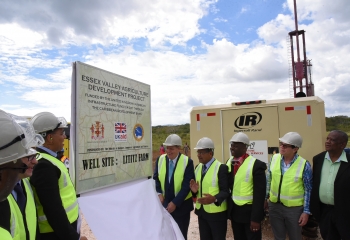 Government officials and stakeholders wear protective gear on a drill site for a project in Jamaica