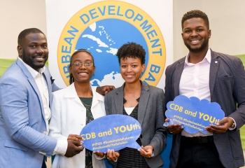 Four smiling young people holding youth-focused social media props