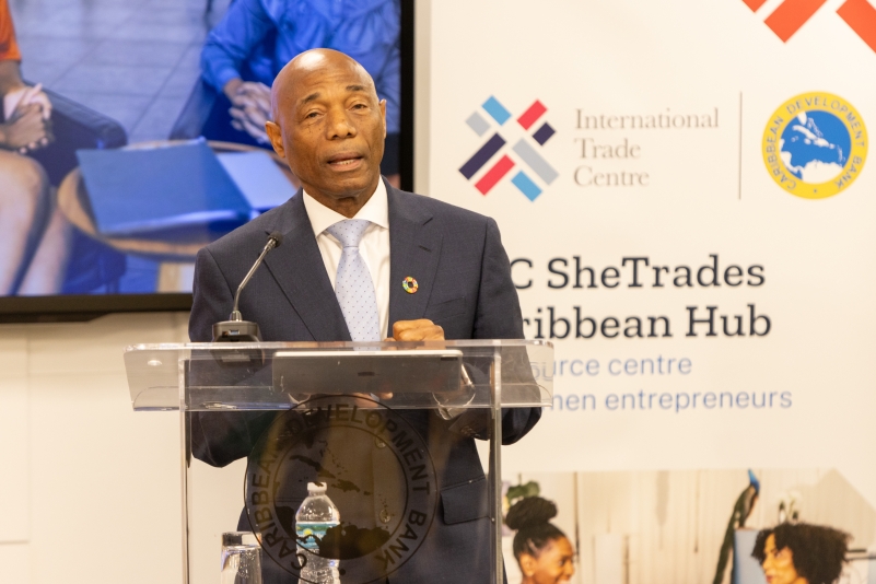 black gentleman in grey business suit with white inside shirt standing at lectern