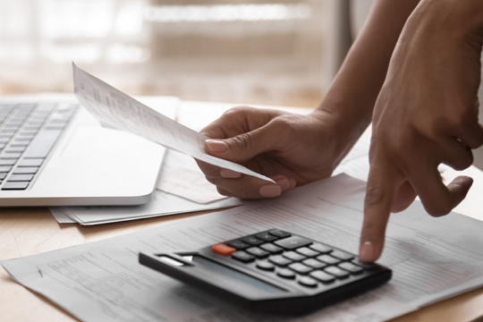 hand using calculator on table